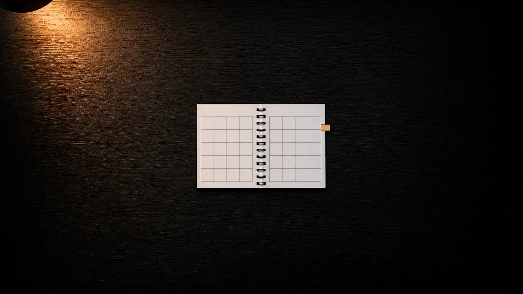 Ein aufgeschlagener Tischkalender ohne lesbare Zahlen, ein Reiter in Amber markiert eine Seite